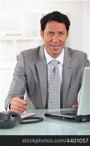 Businessman sitting at his desk with a laptop computer