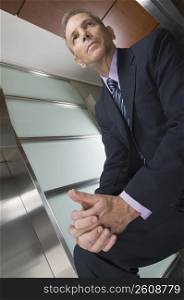 Businessman sitting in a corridor and thinking