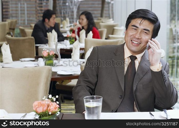 Businessman sitting in a restaurant using a mobile phone