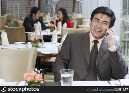 Businessman sitting in a restaurant using a mobile phone