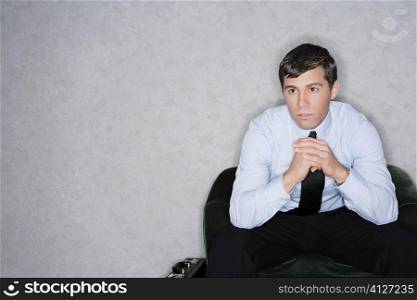 Businessman sitting in an armchair and thinking