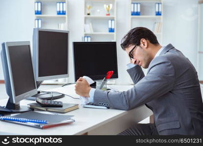 Businessman sitting in front of many screens