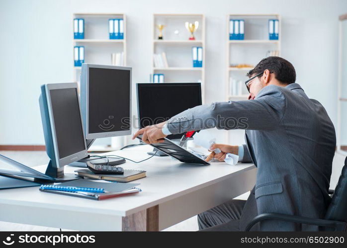 Businessman sitting in front of many screens