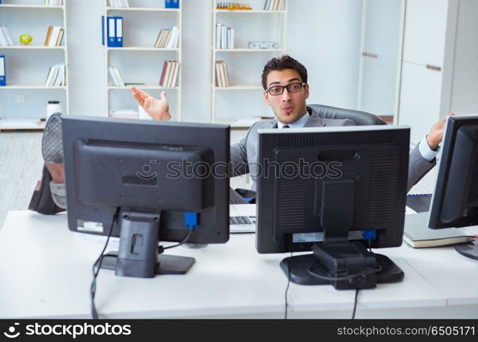 Businessman sitting in front of many screens