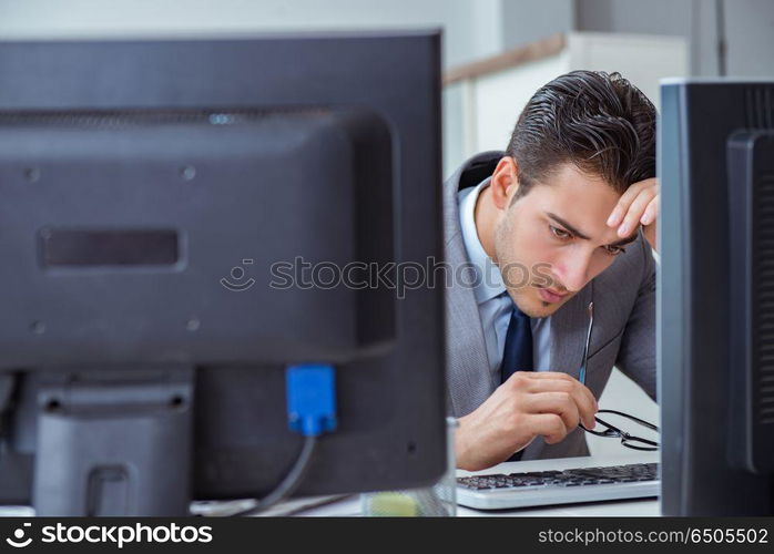 Businessman sitting in front of many screens