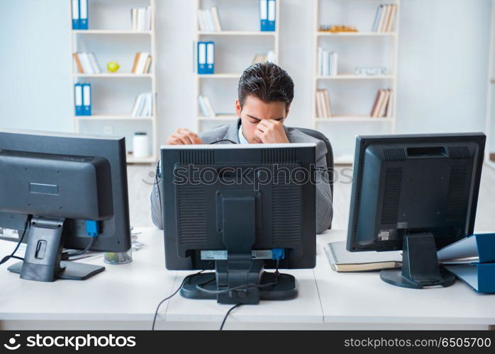 Businessman sitting in front of many screens