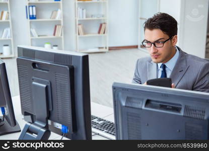 Businessman sitting in front of many screens