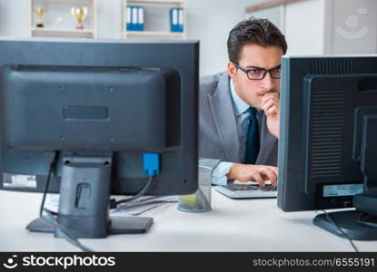 Businessman sitting in front of many screens