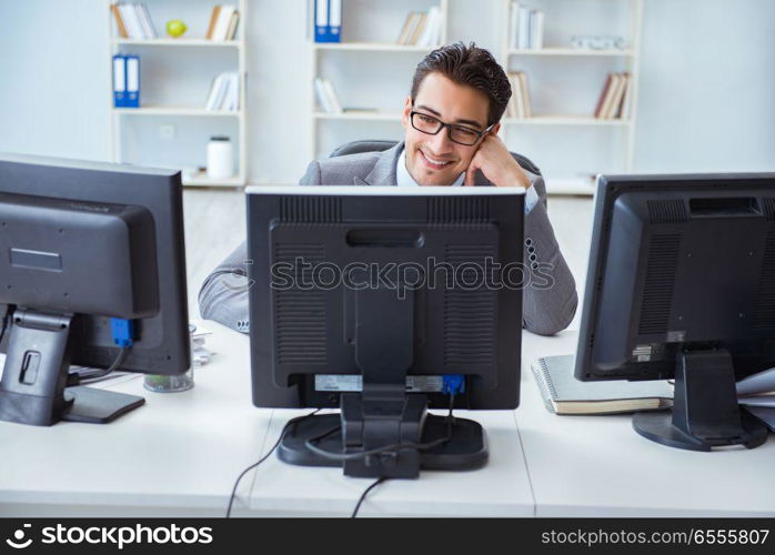 Businessman sitting in front of many screens