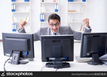 Businessman sitting in front of many screens