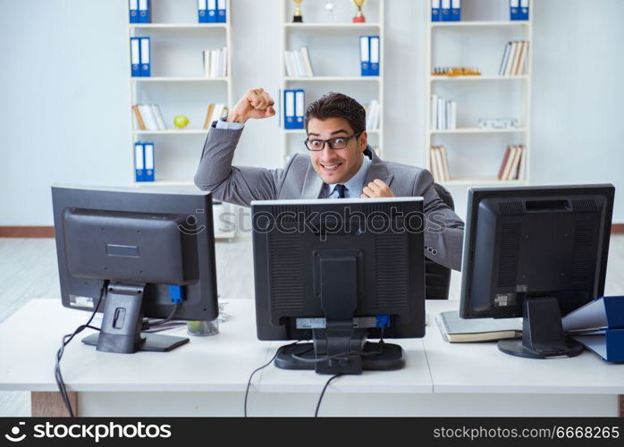 Businessman sitting in front of many screens