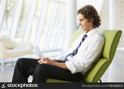 Businessman Sitting In Modern Office Using Digital Tablet