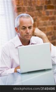Businessman sitting in office on laptop