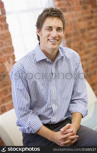 Businessman sitting in office space smiling