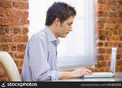 Businessman sitting in office with laptop