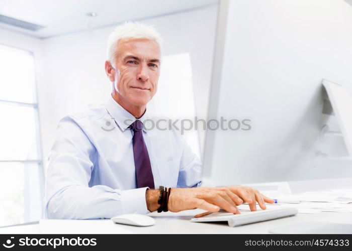 Businessman sitting in office working with computer. Another office day in front of computer