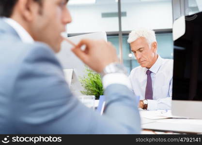 Businessman sitting in office working with computer. Another office day in front of computer