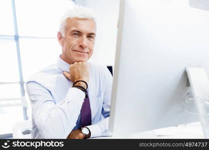 Businessman sitting in office working with computer. Another office day in front of computer