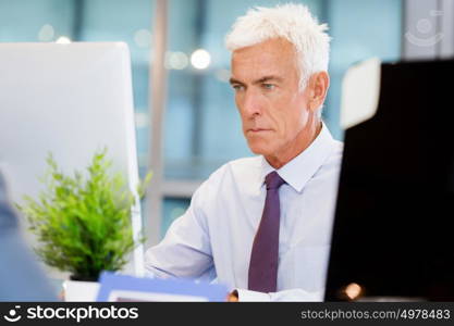 Businessman sitting in office working with computer. Another office day in front of computer