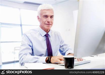 Businessman sitting in office working with computer. Another office day in front of computer