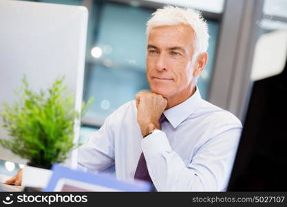 Businessman sitting in office working with computer. Another office day in front of computer