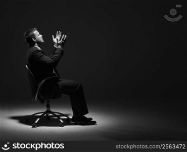 Businessman Sitting In Spotlight