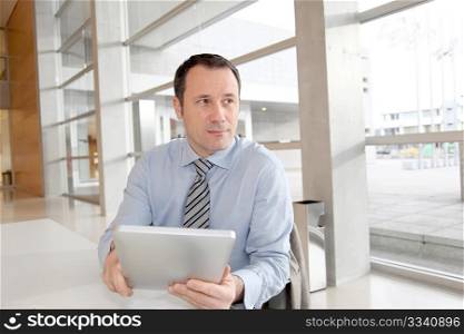 Businessman sitting in the office with electronic tablet