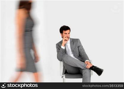Businessman sitting in waiting room and woman walking by