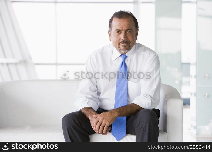 Businessman sitting indoors (high key/selective focus)