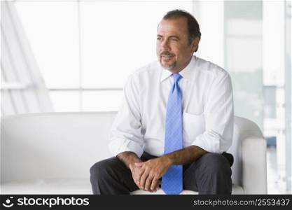 Businessman sitting indoors (high key/selective focus)
