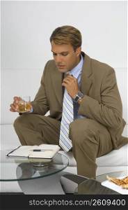 Businessman sitting on a couch and holding a glass of wine