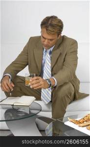 Businessman sitting on a couch and looking at a diary