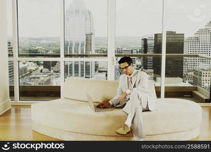 Businessman sitting on a couch and using a laptop