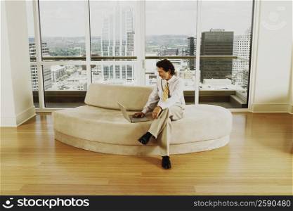 Businessman sitting on a couch and using a laptop