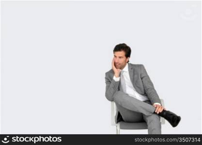 Businessman sitting on chair on grey background