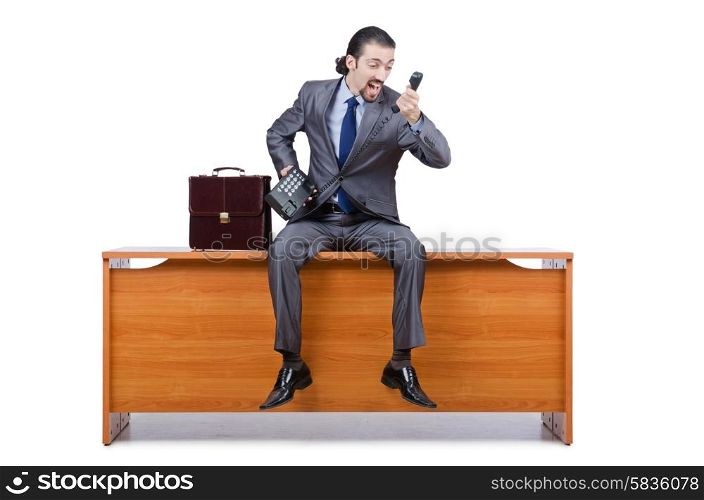 Businessman sitting on desk and speaking phone