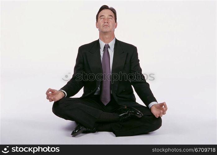 Businessman sitting on the floor meditating