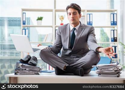 Businessman sitting on top of desk in office. The businessman sitting on top of desk in office