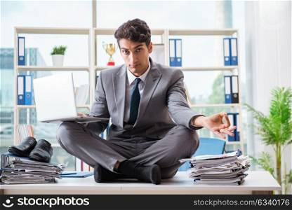 Businessman sitting on top of desk in office. The businessman sitting on top of desk in office
