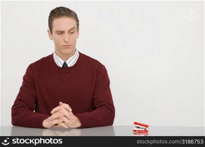 Businessman sitting with his hands clasped and looking at dentures