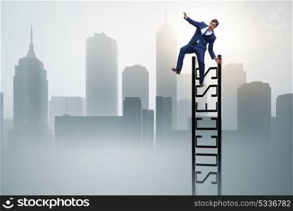 Businessman slipping from the top of ladder