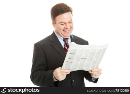 Businessman smiles as he reads his morning newspaper. Isolated on white.