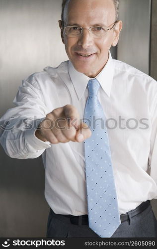 Businessman smiling and pointing forward in an office