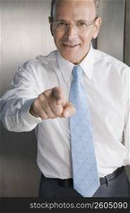 Businessman smiling and pointing forward in an office