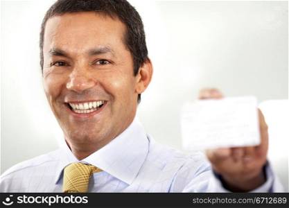 businessman smiling and showing his business card in an office