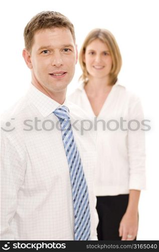 Businessman smiling with a businesswoman standing behind him