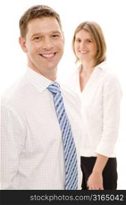 Businessman smiling with a businesswoman standing behind him