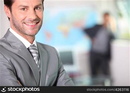 Businessman smiling with arms folded
