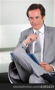 Businessman smiling with notepad.