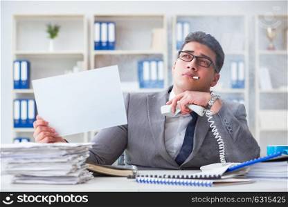 Businessman smoking at work in office holding a blank message bo. Businessman smoking at work in office holding a blank message board